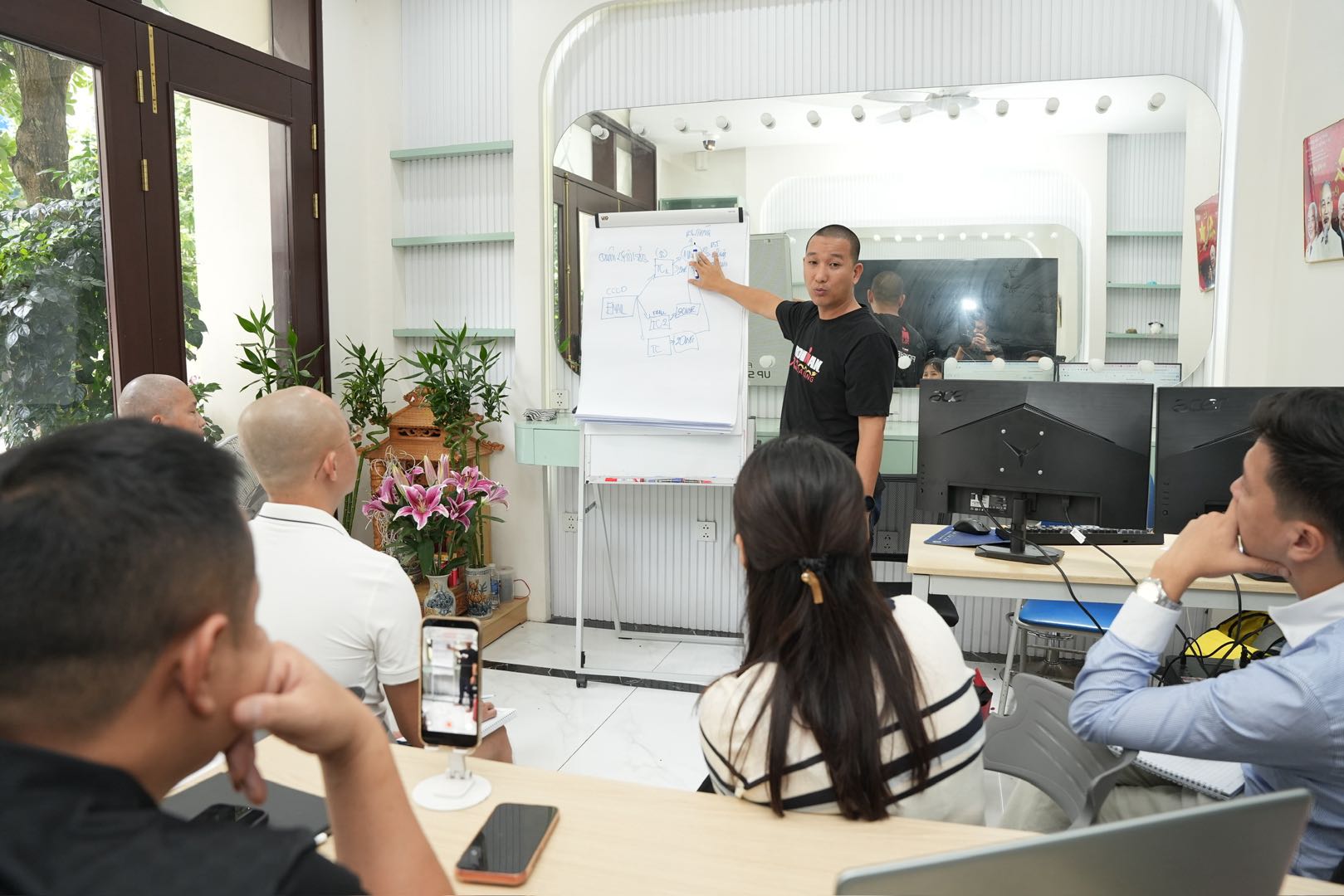 Thầy Hóa chỉ vào sơ đồ flowchart Claude Cloudflare SePay trên bảng trắng