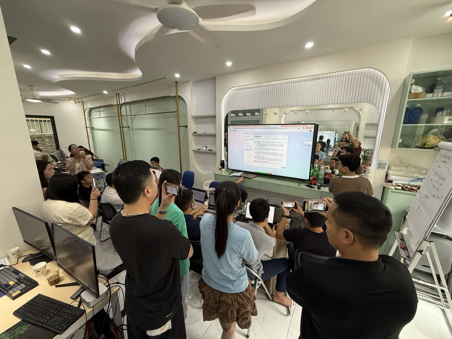 Đông đảo học viên đứng quanh màn hình lớn chụp lại kết quả salepage vừa tạo bằng Claude AI